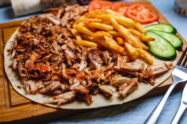 Free Photo side view doner on pita with french fries fresh cucumber and tomato