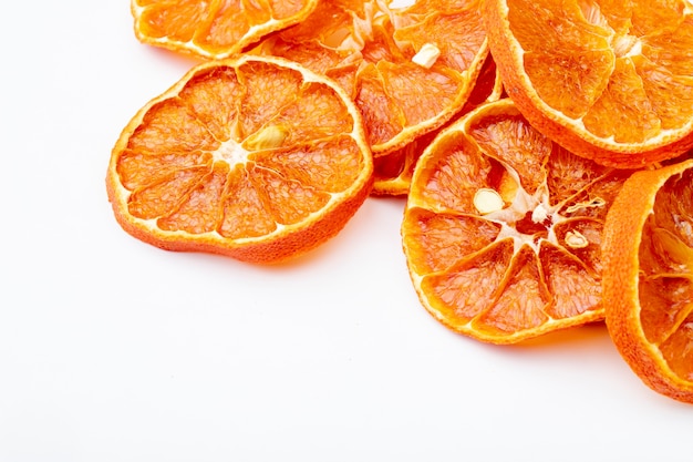 Side view of dried orange slices arranged on white background with copy space