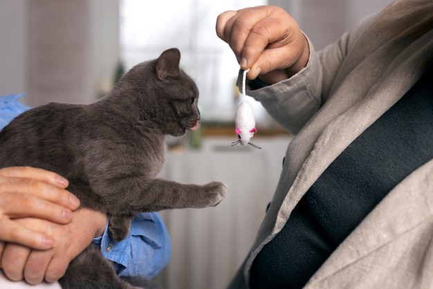 Free photo side view elderly people with cat