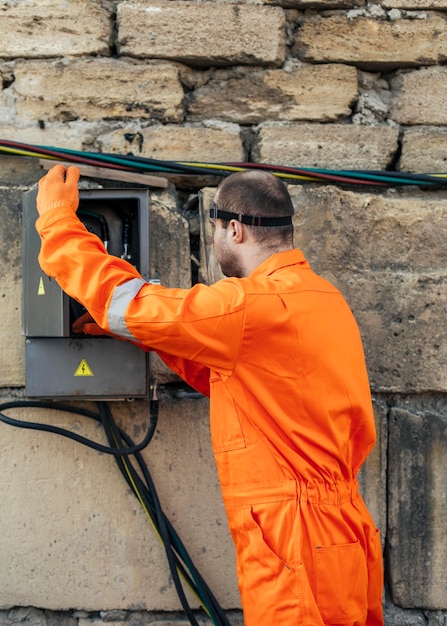 Free Photo side view of electrician with uniform and face shield