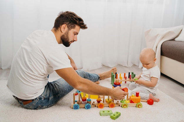 Free photo side view of father playing with his baby