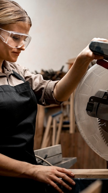 Free photo side view of female carpenter with glasses and tool