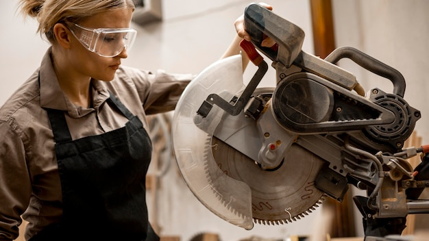 Side view of female carpenter with tool and glasses