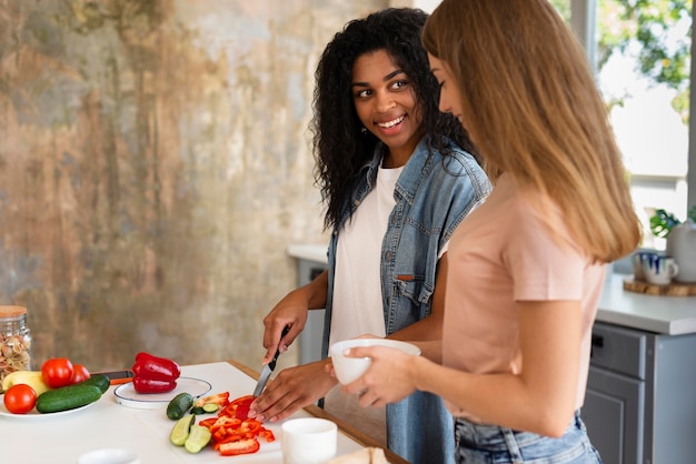 Side view of female friends cooking together in the kitchen