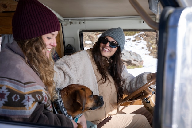 Side view of female lovers with their dog during winter trip