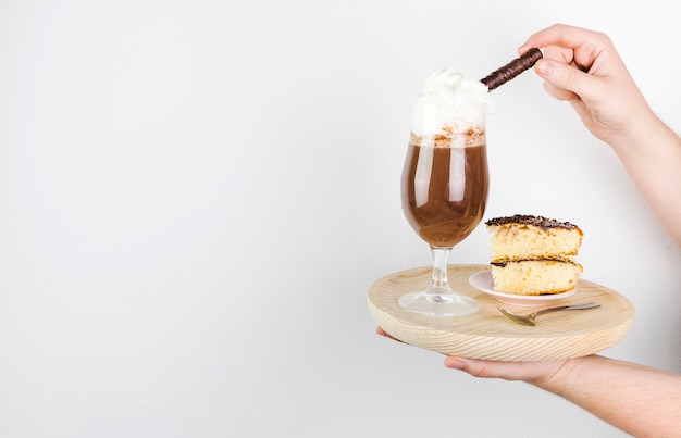 Side view frappe and cake on a wooden plate