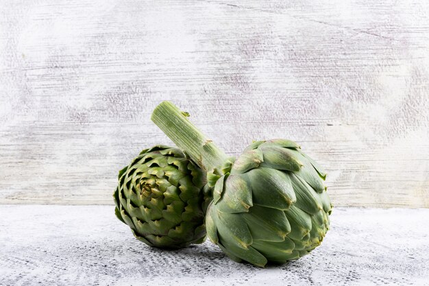 Side view fresh artichoke on light gray background. horizontal