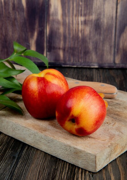 Side view of fresh ripe nectarines on wooden board on rustic background