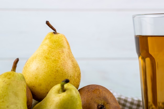 Free photo side view of fresh ripe pears on white wooden background