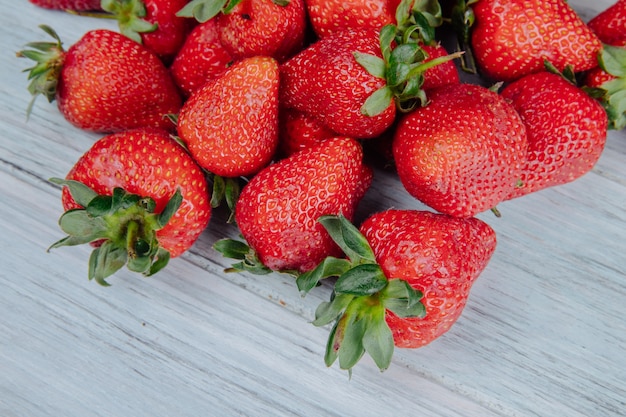 Side view of fresh ripe strawberries on white wood