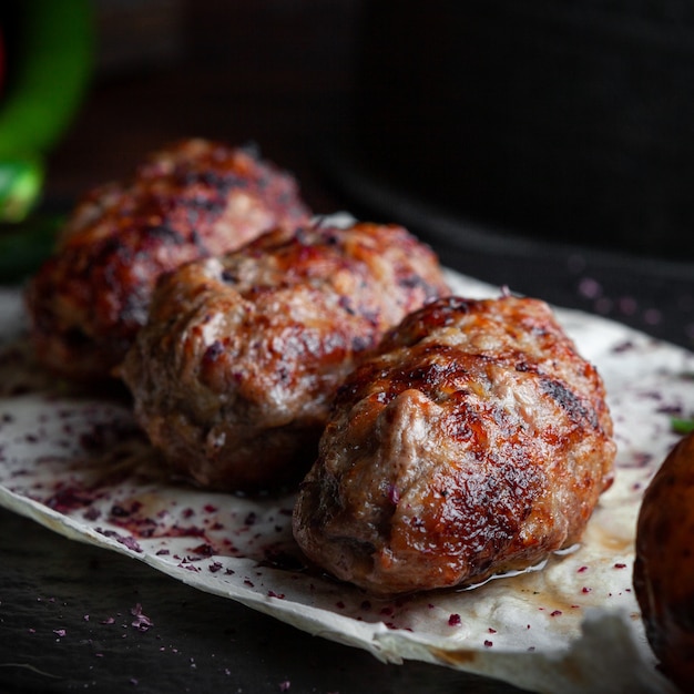 Free photo side view fried meat in dark plate