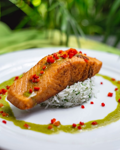 Side view fried red fish with boiled rice and sauce