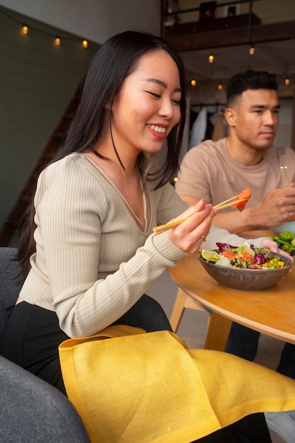 Side view friends eating salmon bowls