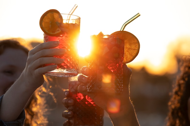 Side view friends holding sangria drinks