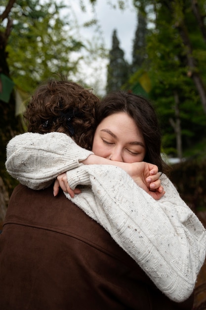 Side view friends hugging in nature