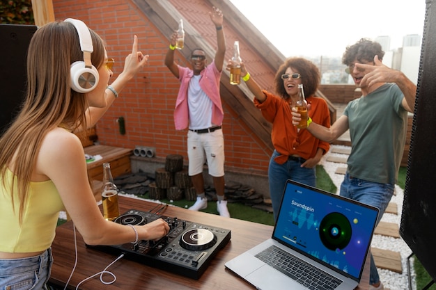 Free photo side view friends partying on roof