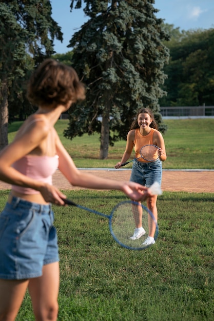 Side view friends playing badminton