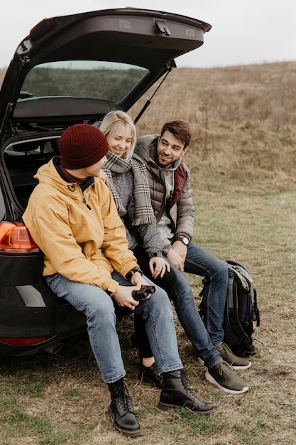 Free photo side view friends sitting in car