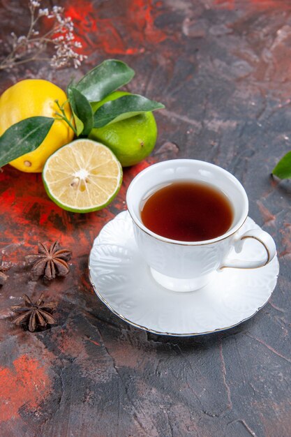 Side view from afar a cup of tea a cup of black tea lemons with leaves star anise