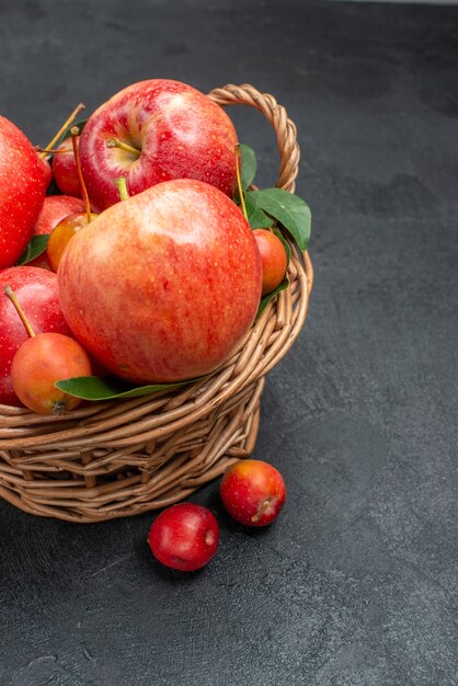 Side view fruits red-yellow cherries and apples in the basket