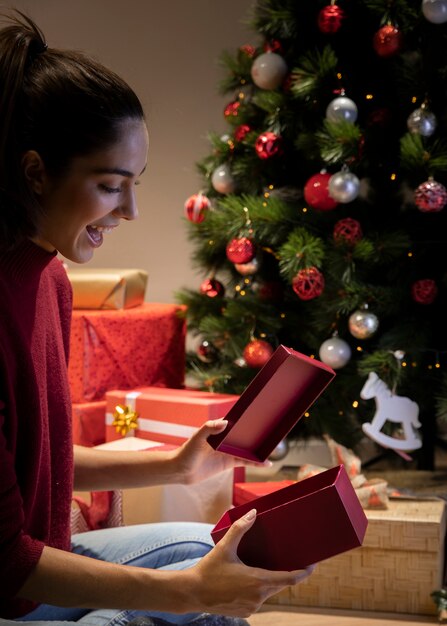 Side view fsmiley woman opening gift