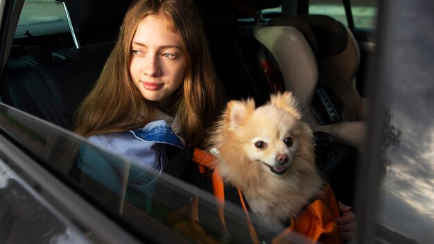 Side view girl and dog in car