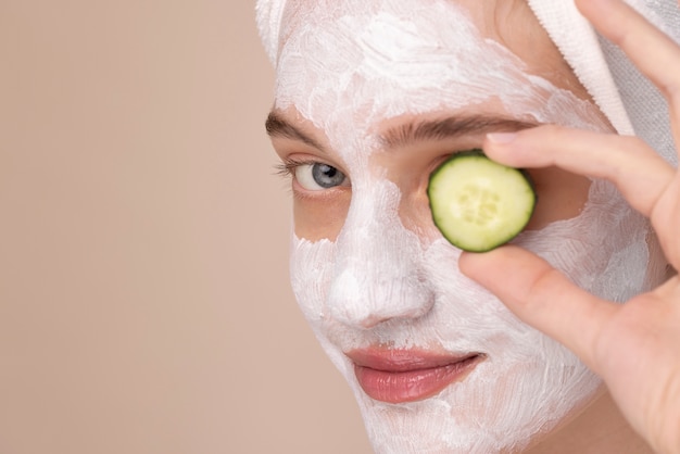 Side view girl holding cucumber slice