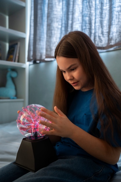 Side view girl interacting with a plasma ball