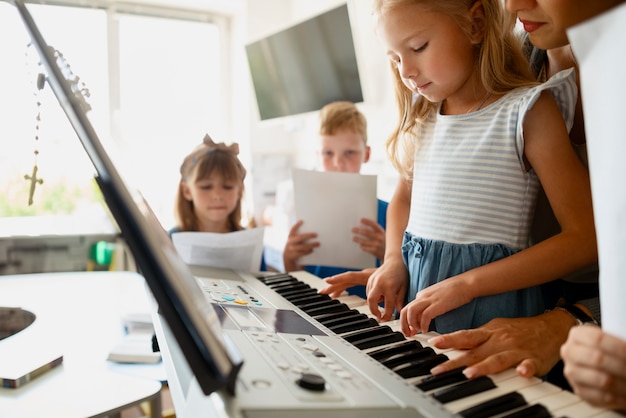 Free Photo side view girl learning to play the piano