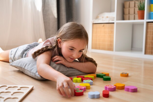 Side view girl making puzzle on floor