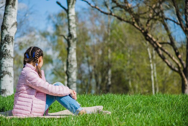 Side view of girl sitting on grass