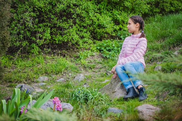 Free photo side view of girl sitting outdoors