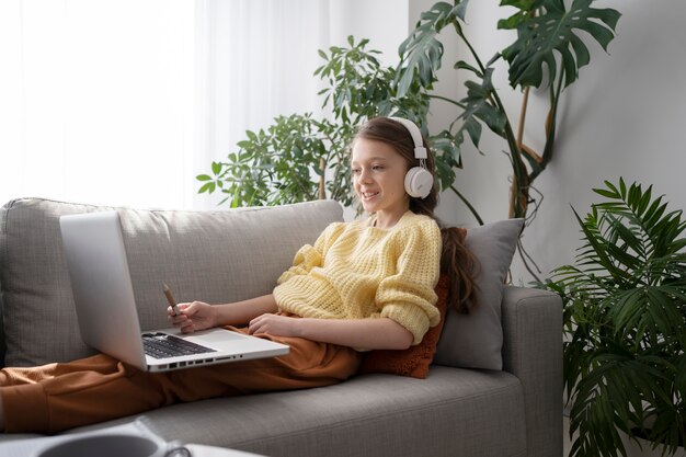 Side view girl with laptop on couch