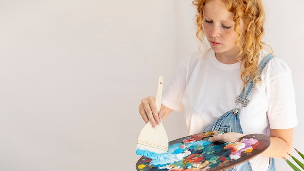 Free photo side view girl with painting items