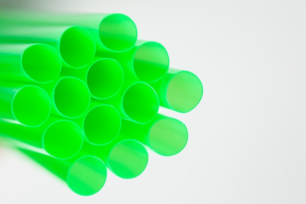 Free photo side view green plastic drinking straws