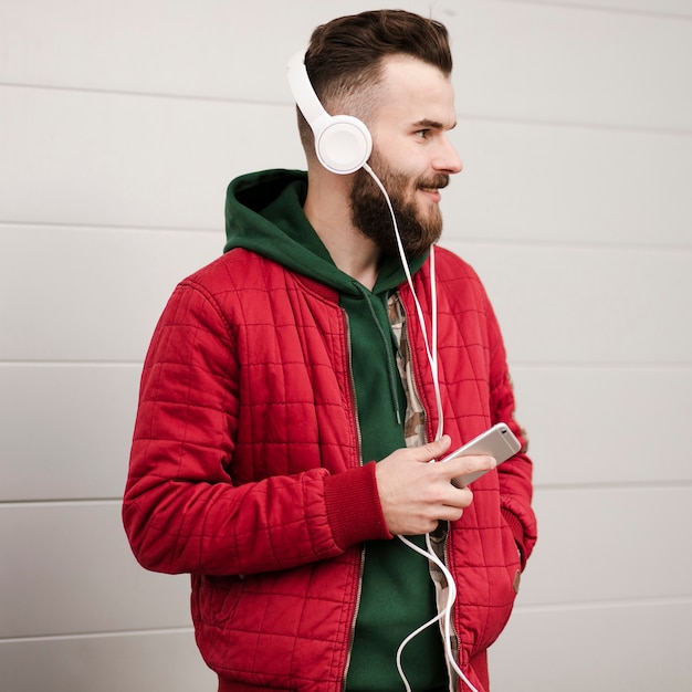 Side view guy with beard and smartphone