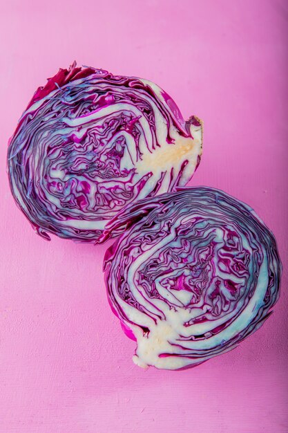 Side view of half cut purple cabbage on purple background with copy space