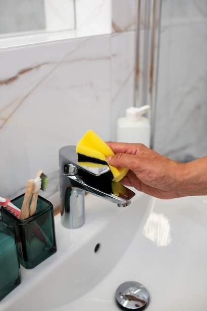 Free photo side view hand cleaning the sink