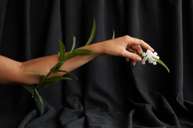 Free Photo side view hand holding flower