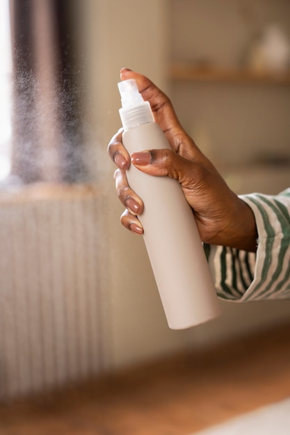 Free Photo side view hand holding hair spray