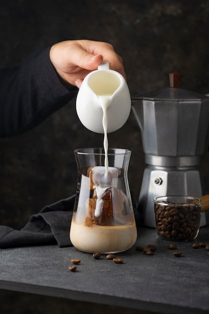 Free photo side view hand pouring milk in cup