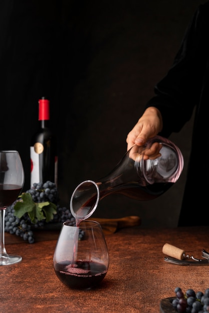 Free photo side view hand pouring wine in glass