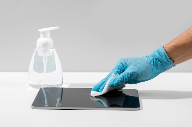 Side view of hand with surgical glove disinfecting tablet on desk