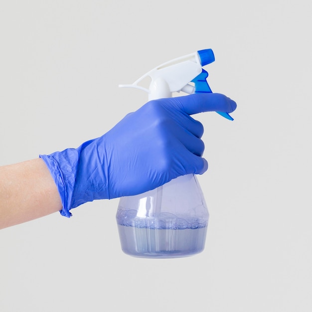 Side view of hand with surgical glove holding ablution bottle