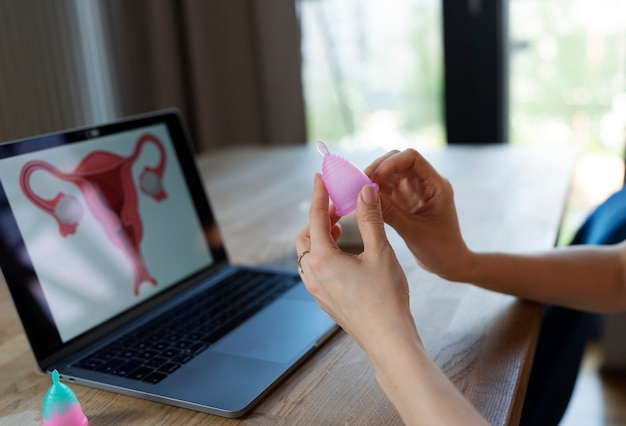 Side view hands holding menstrual cup