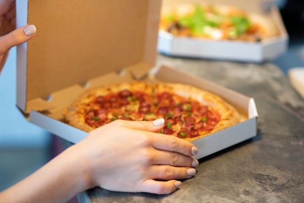 Free photo side view hands holding pizza