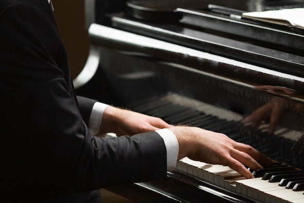 Side view hands playing piano