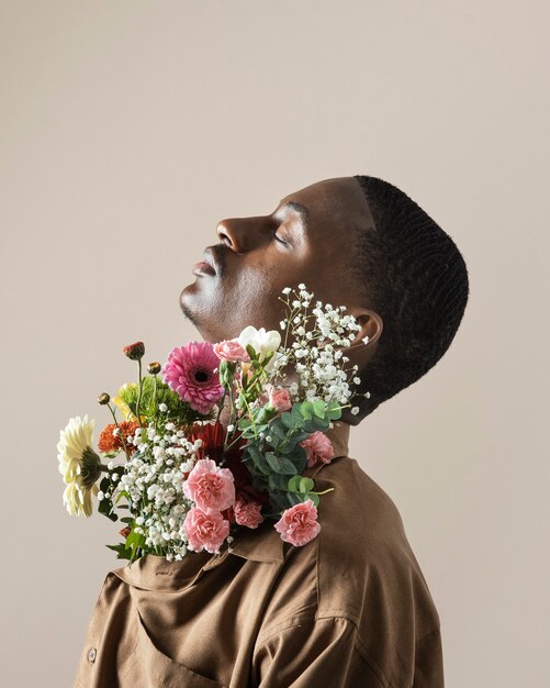 Side view of handsome man posing with bouquet of flowers