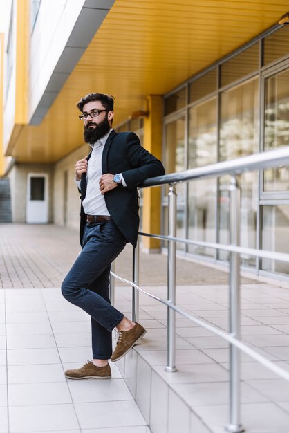 Side view of a handsome young businessman standing near the railing