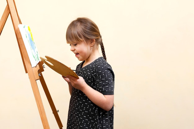 Side view of happy girl with down syndrome painting